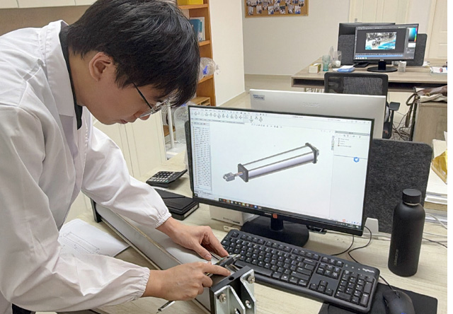 Fescolo engineer inspecting a finished custom pneumatic cylinder against an approved drawing.jpg Fescolo engineer inspecting a finished custom pneumatic cylinder against an approved drawing.jpg